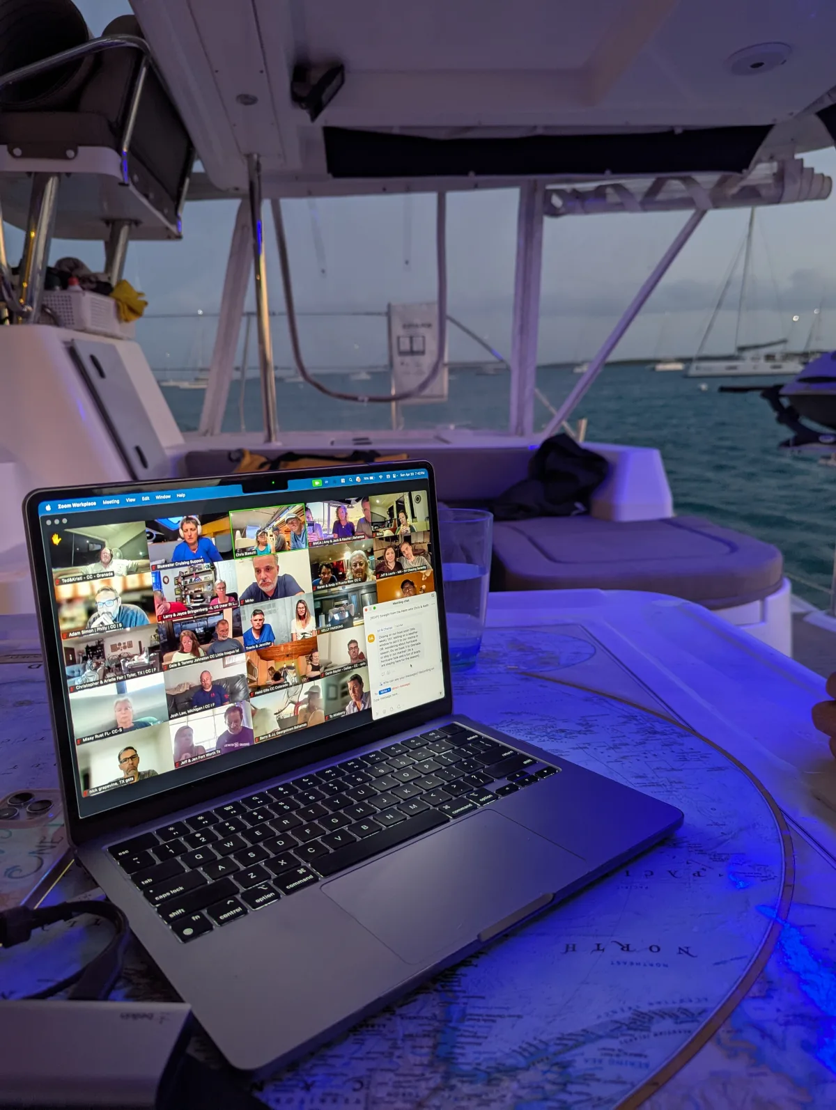 Laptop open to a Zoom call on the deck of a boat