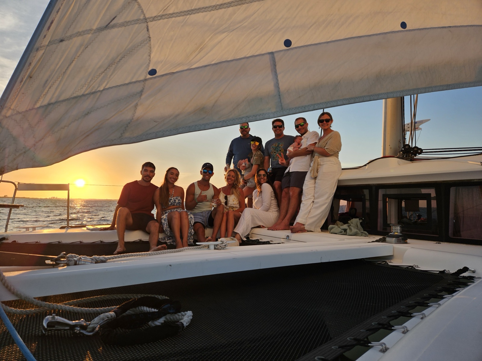 Oceans of Fun, a Lagoon 400 S2 sail catamaran, with the crew aboard at sunset