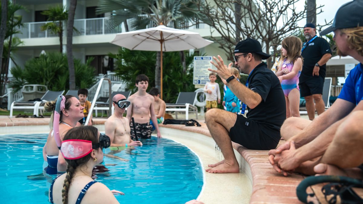 Guests in the pool listening to the freediving instructor